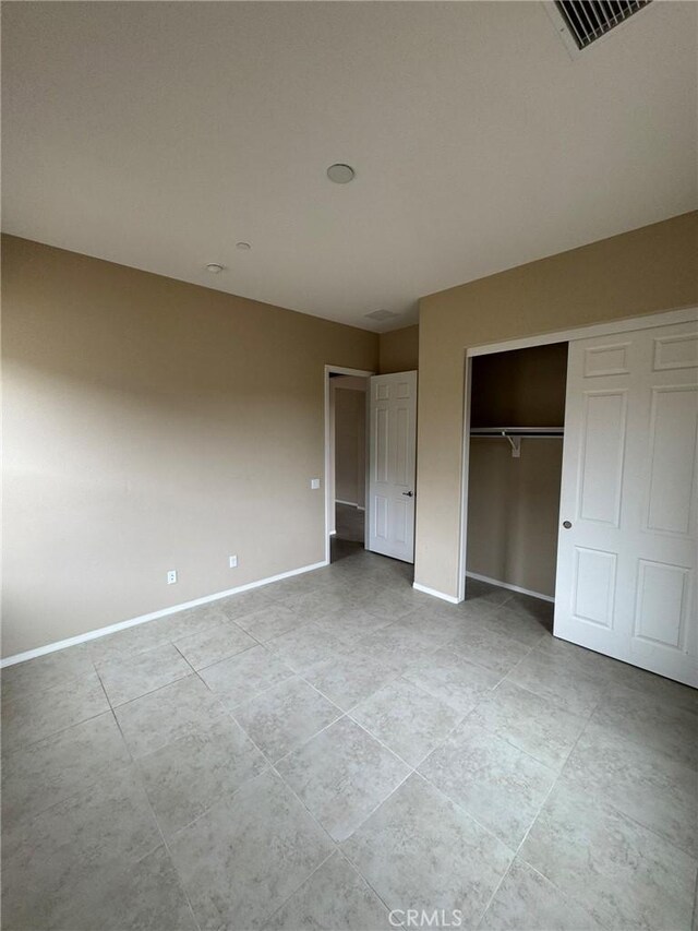 1572 Humboldt Peak, Beaumont, CA 92223 - unfurnished bedroom featuring baseboards, a closet, and light tile patterned floors