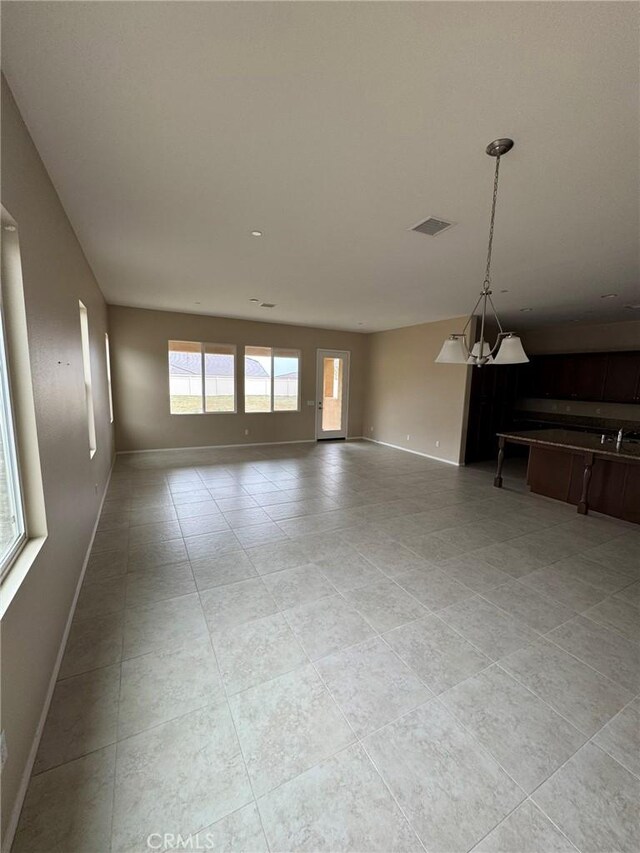 1572 Humboldt Peak, Beaumont, CA 92223 - unfurnished living room featuring baseboards, light tile patterned flooring, and a sink