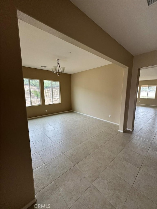 1572 Humboldt Peak, Beaumont, CA 92223 - unfurnished room with healthy amount of natural light, a chandelier, light tile patterned floors, and baseboards