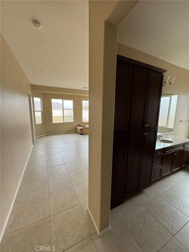 1572 Humboldt Peak, Beaumont, CA 92223 - hall featuring light tile patterned flooring, baseboards, and a sink