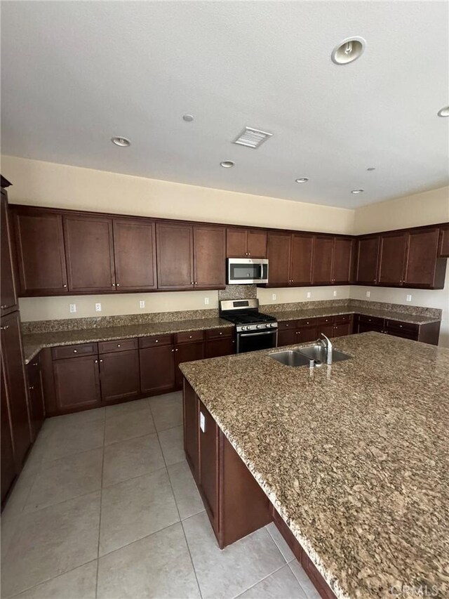 1572 Humboldt Peak, Beaumont, CA 92223 - kitchen with appliances with stainless steel finishes, a sink, dark stone countertops, light tile patterned floors, and dark brown cabinetry