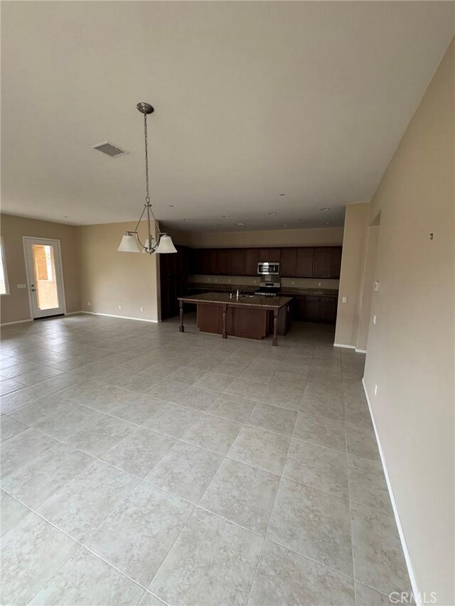 1572 Humboldt Peak, Beaumont, CA 92223 - kitchen with open floor plan, stainless steel microwave, and light tile patterned flooring