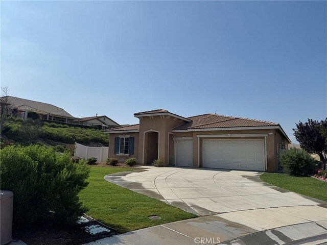 1572 Humboldt Peak, Beaumont, CA 92223 - mediterranean / spanish house featuring stucco siding, a tiled roof, an attached garage, and driveway