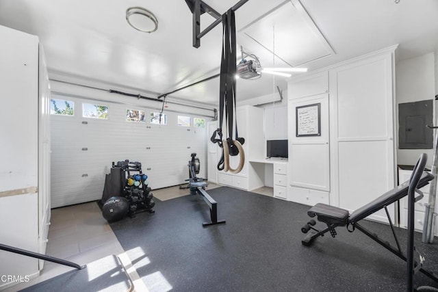 exercise area featuring electric panel and attic access