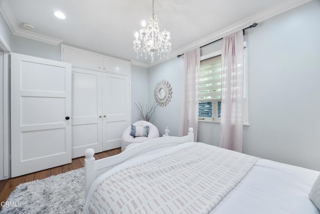 bedroom with ornamental molding, wood finished floors, recessed lighting, a closet, and an inviting chandelier