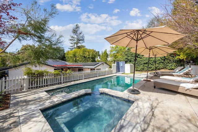 view of pool with a pool with connected hot tub, a fenced backyard, and a patio area