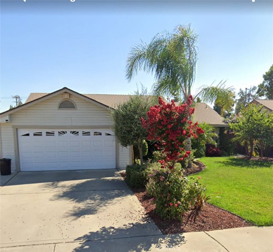 view of front facade featuring concrete driveway, an attached garage, and a front lawn