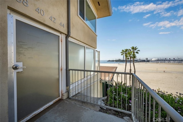 balcony featuring a water view and a view of the beach