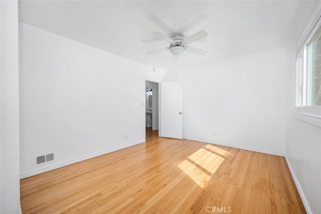 unfurnished room featuring a ceiling fan, baseboards, visible vents, and wood finished floors