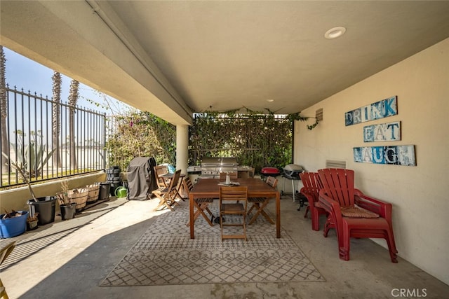 view of patio featuring outdoor dining area, fence, and area for grilling