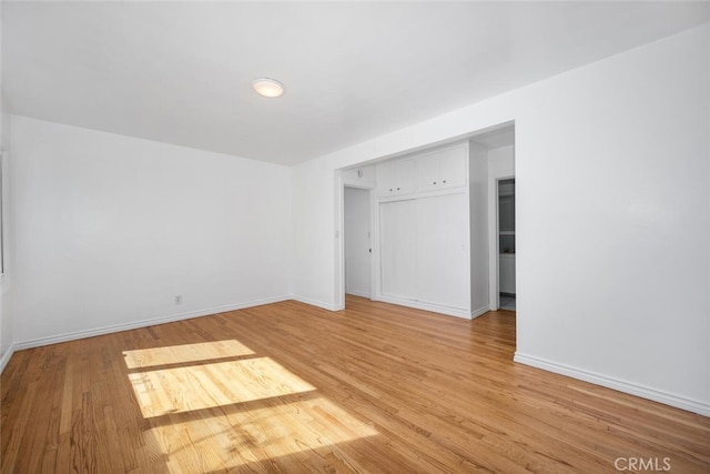 empty room featuring baseboards and light wood-style flooring