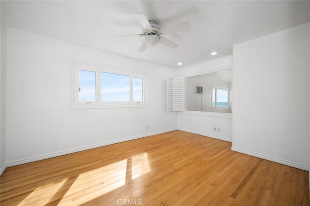 empty room with light wood-type flooring, a ceiling fan, baseboards, and recessed lighting