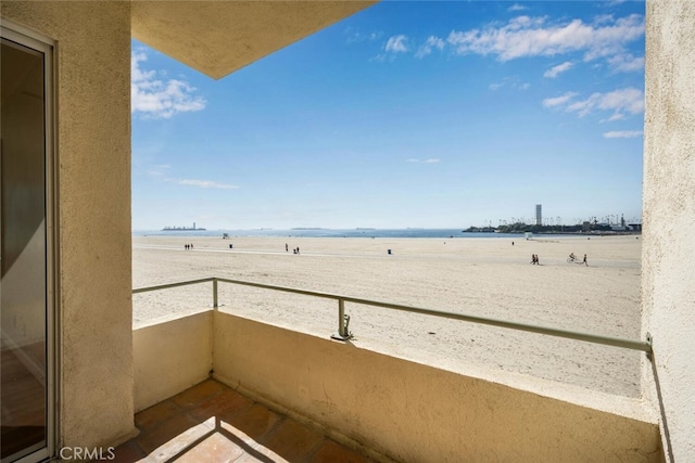 balcony featuring a water view and a beach view