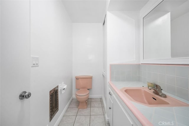 bathroom with visible vents, vanity, tile patterned floors, baseboards, and toilet