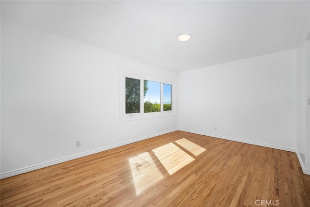empty room with baseboards and wood finished floors