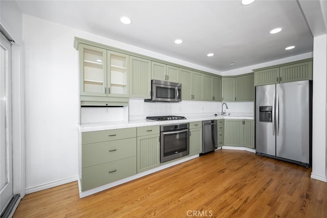 kitchen with stainless steel appliances, light wood-style floors, recessed lighting, and green cabinets