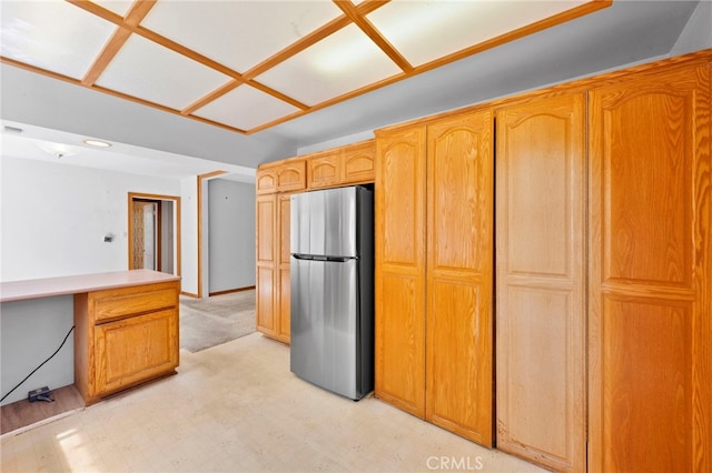 kitchen featuring light floors, light countertops, and freestanding refrigerator