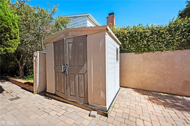 view of shed featuring fence