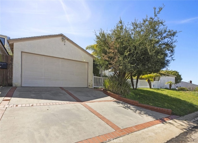 view of front facade featuring a front lawn, fence, stucco siding, a garage, and driveway