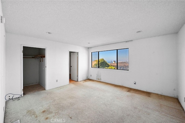 unfurnished bedroom featuring a textured ceiling and carpet