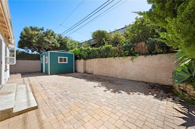 view of patio featuring an outbuilding, a storage shed, and a fenced backyard