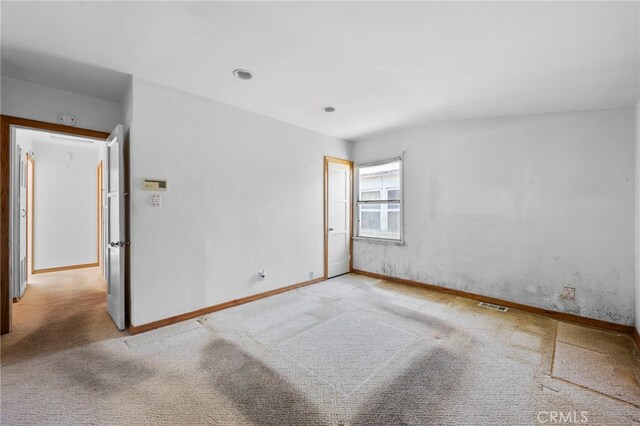 empty room with visible vents, baseboards, and carpet floors