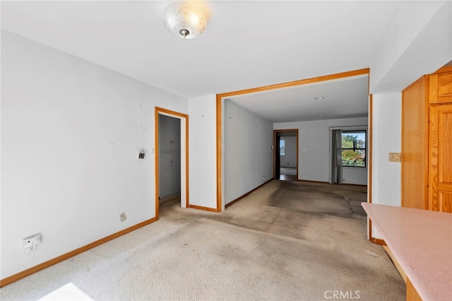 spare room with light colored carpet and baseboards