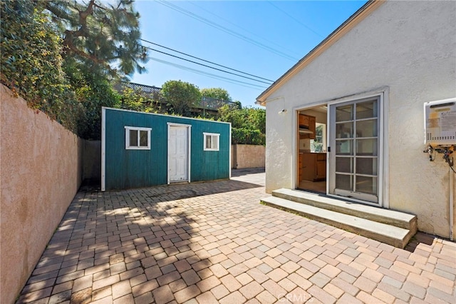 view of patio with an outbuilding, a fenced backyard, and entry steps