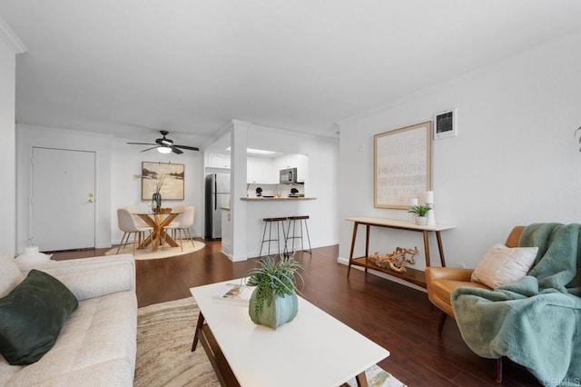 living room featuring visible vents, ornamental molding, a ceiling fan, and wood finished floors