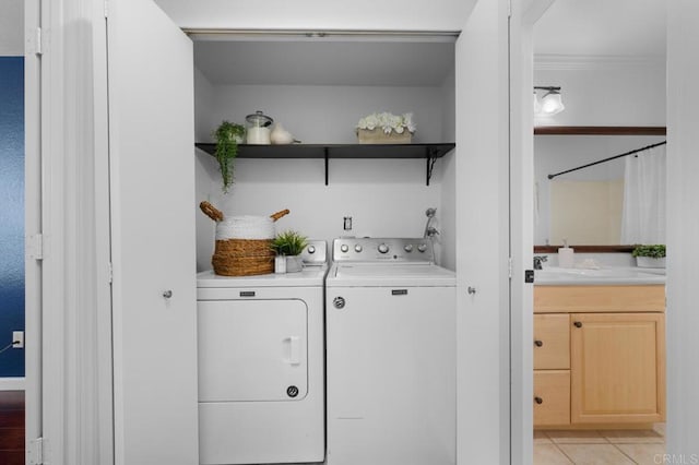 washroom featuring light tile patterned floors, washing machine and dryer, laundry area, and crown molding