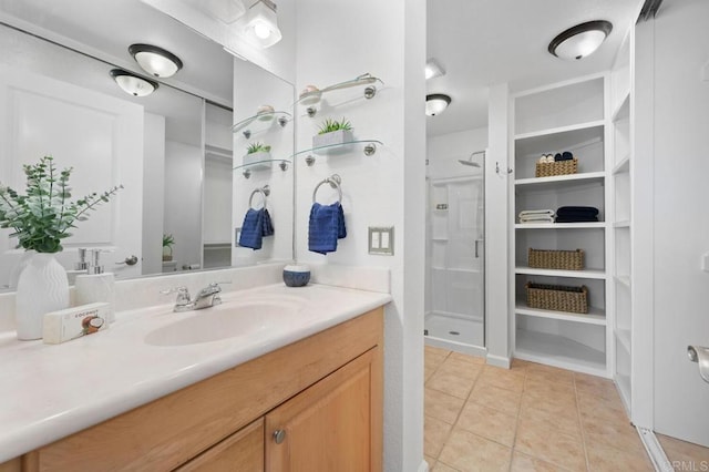 full bath featuring tile patterned flooring, vanity, and a stall shower