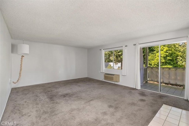 2405 Via Mariposa W Unit 2G, Laguna Woods, CA 92637 - spare room featuring a wall mounted air conditioner, carpet floors, and a textured ceiling