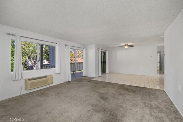 2405 Via Mariposa W Unit 2G, Laguna Woods, CA 92637 - carpeted empty room with a textured ceiling, ceiling fan, and a wall unit AC