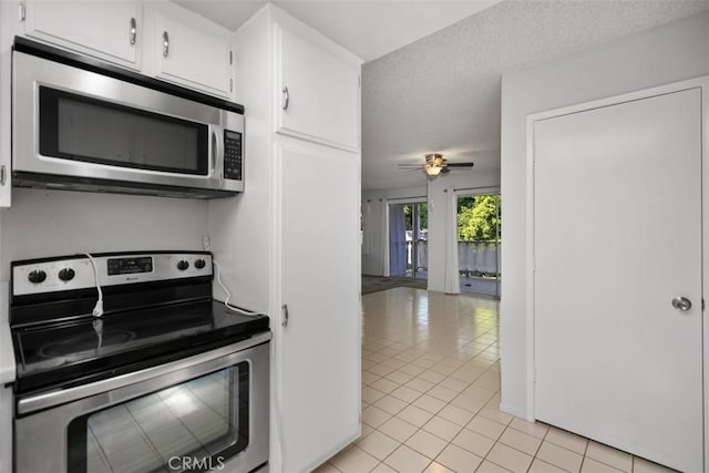2405 Via Mariposa W Unit 2G, Laguna Woods, CA 92637 - kitchen featuring appliances with stainless steel finishes, light tile patterned flooring, white cabinetry, and a ceiling fan