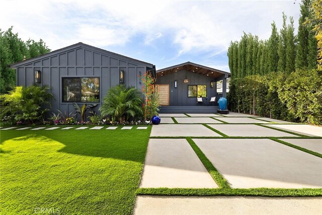 view of front of property with board and batten siding and a front yard
