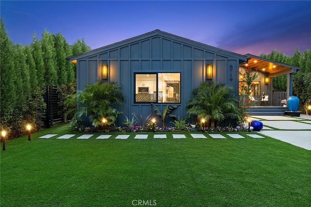 view of front facade with board and batten siding and a yard