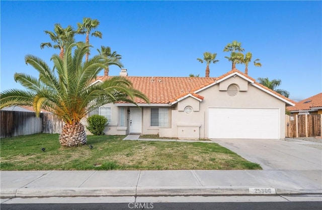 view of front of house with a front yard, fence, stucco siding, a garage, and a tiled roof