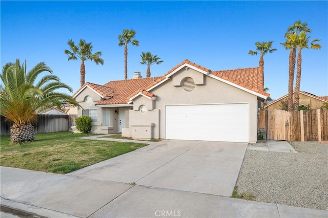 mediterranean / spanish-style home with stucco siding, a tiled roof, a front lawn, and fence