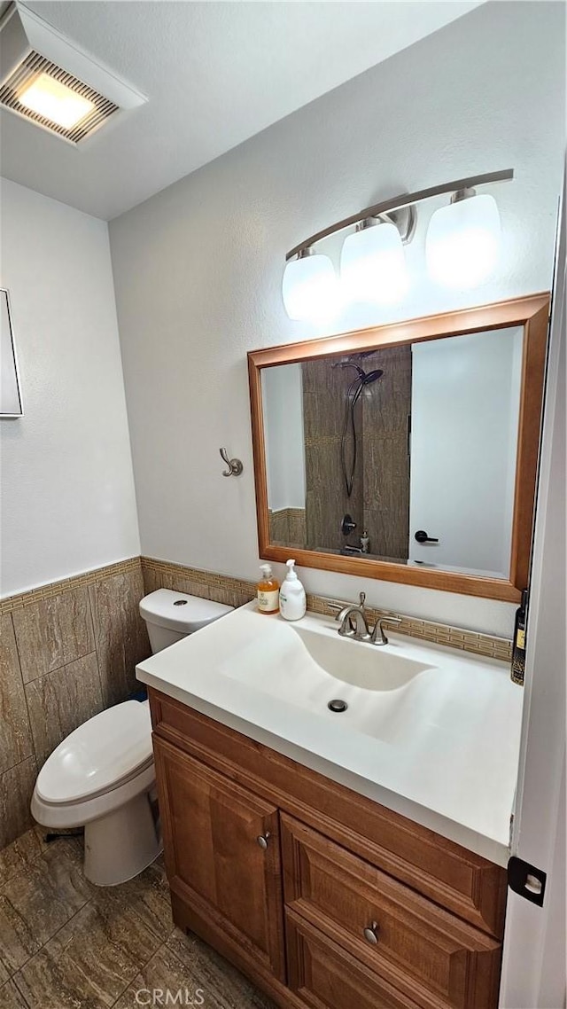 8166 Laguna Ct, Stanton, CA 90680 - bathroom featuring vanity, toilet, visible vents, wainscoting, and tile walls