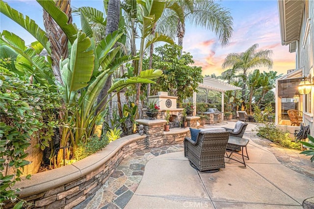 22432 Rosebriar, Mission Viejo, CA 92692 - patio terrace at dusk featuring an outdoor stone fireplace, a patio area, and a pergola