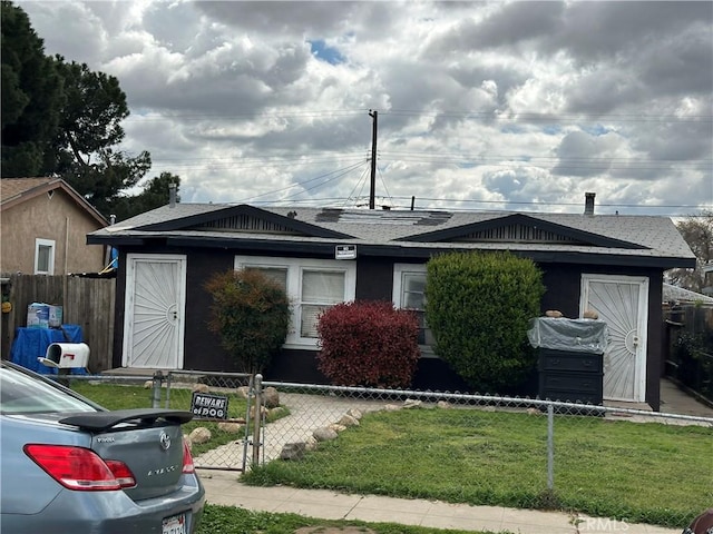 view of front facade with a front lawn and a fenced front yard