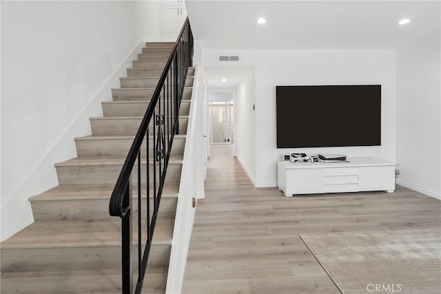 stairs with recessed lighting, wood finished floors, visible vents, and baseboards