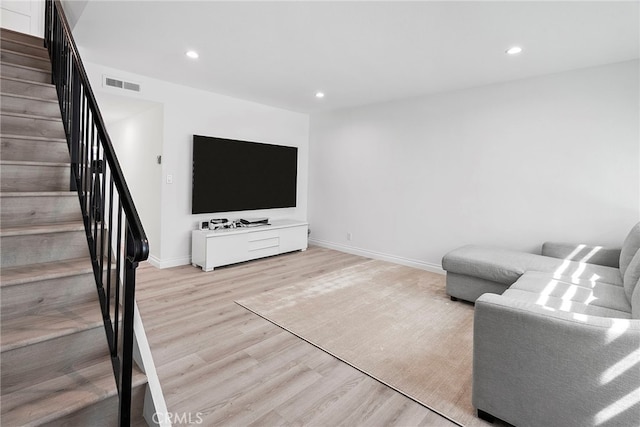 living area featuring stairs, light wood-style flooring, recessed lighting, and visible vents