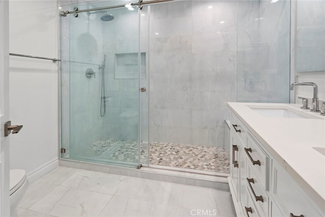 bathroom with toilet, marble finish floor, a stall shower, a sink, and double vanity