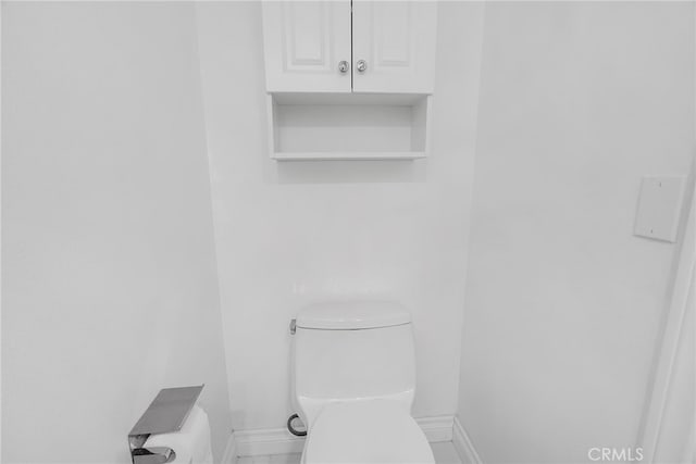 bathroom featuring toilet and baseboards