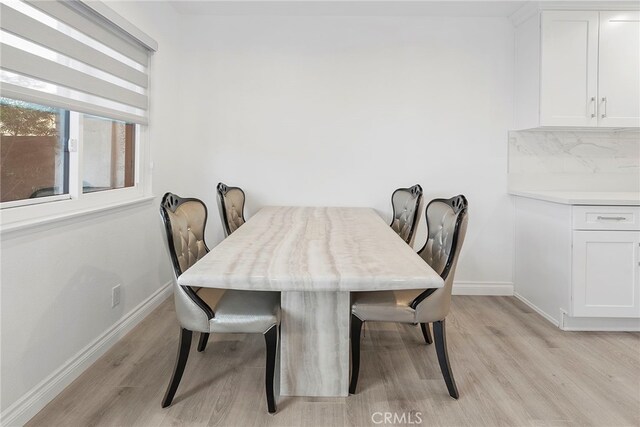 dining room featuring light wood-type flooring and baseboards