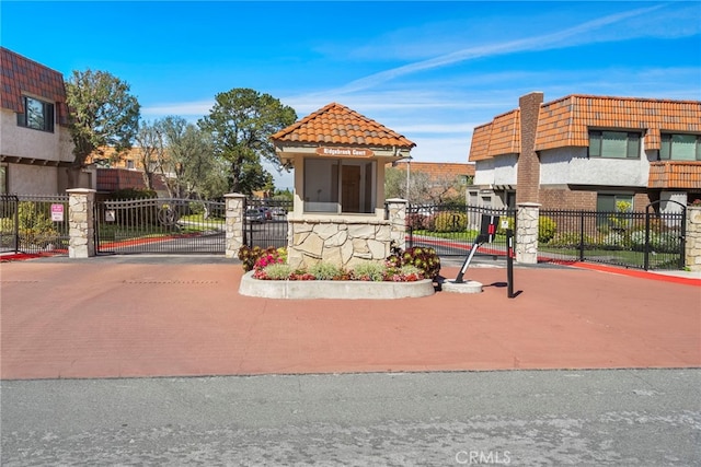 exterior space featuring a gate, curbs, and a gated entry