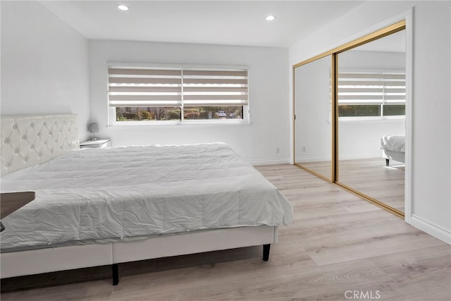 bedroom featuring a closet, recessed lighting, baseboards, and wood finished floors