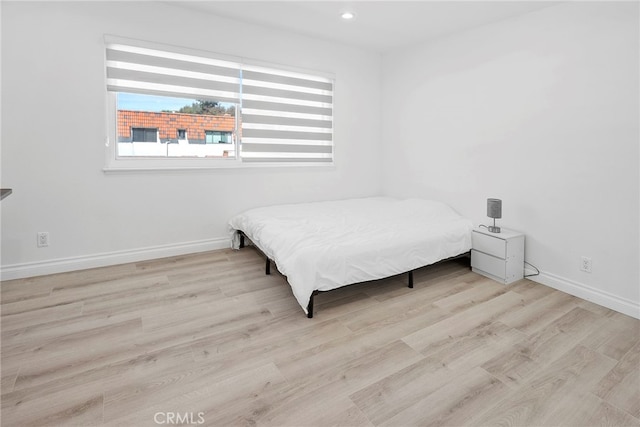 bedroom with recessed lighting, wood finished floors, and baseboards