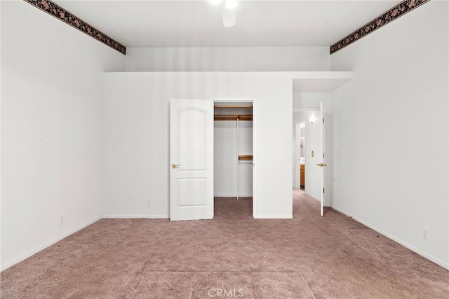 unfurnished bedroom featuring a closet, baseboards, and carpet flooring